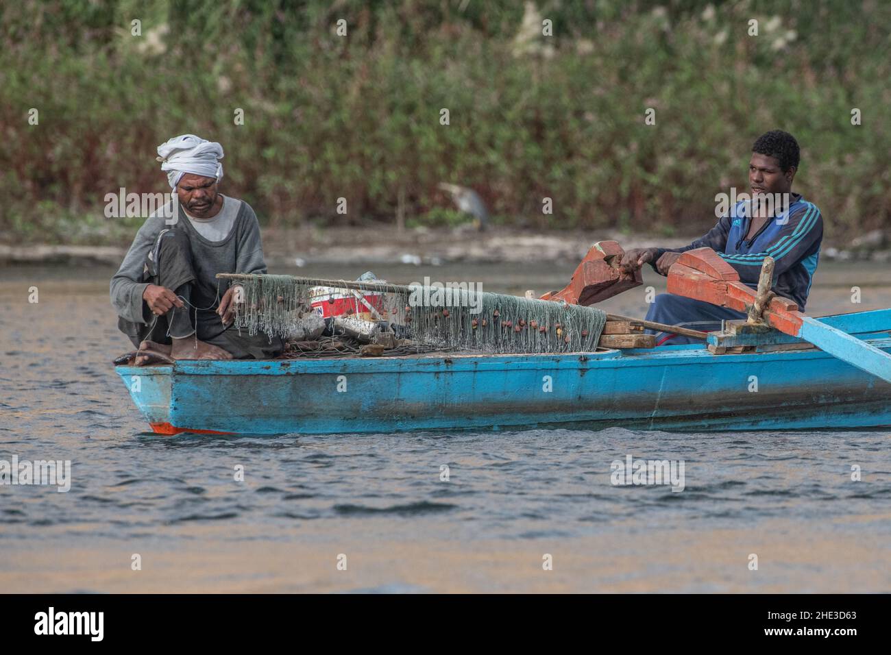 Gli uomini baiting ganci e rete da pesca in una piccola barca nel lago Nasser, parte del fiume Nilo in Egitto. Foto Stock