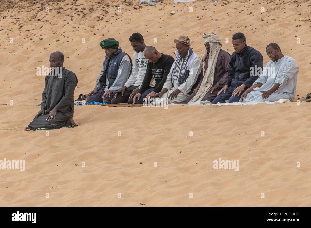 Un gruppo di uomini musulmani fa la loro preghiera rituale quotidiana, Salat, sulle rive del Nilo ad Assuan, Egitto. Foto Stock