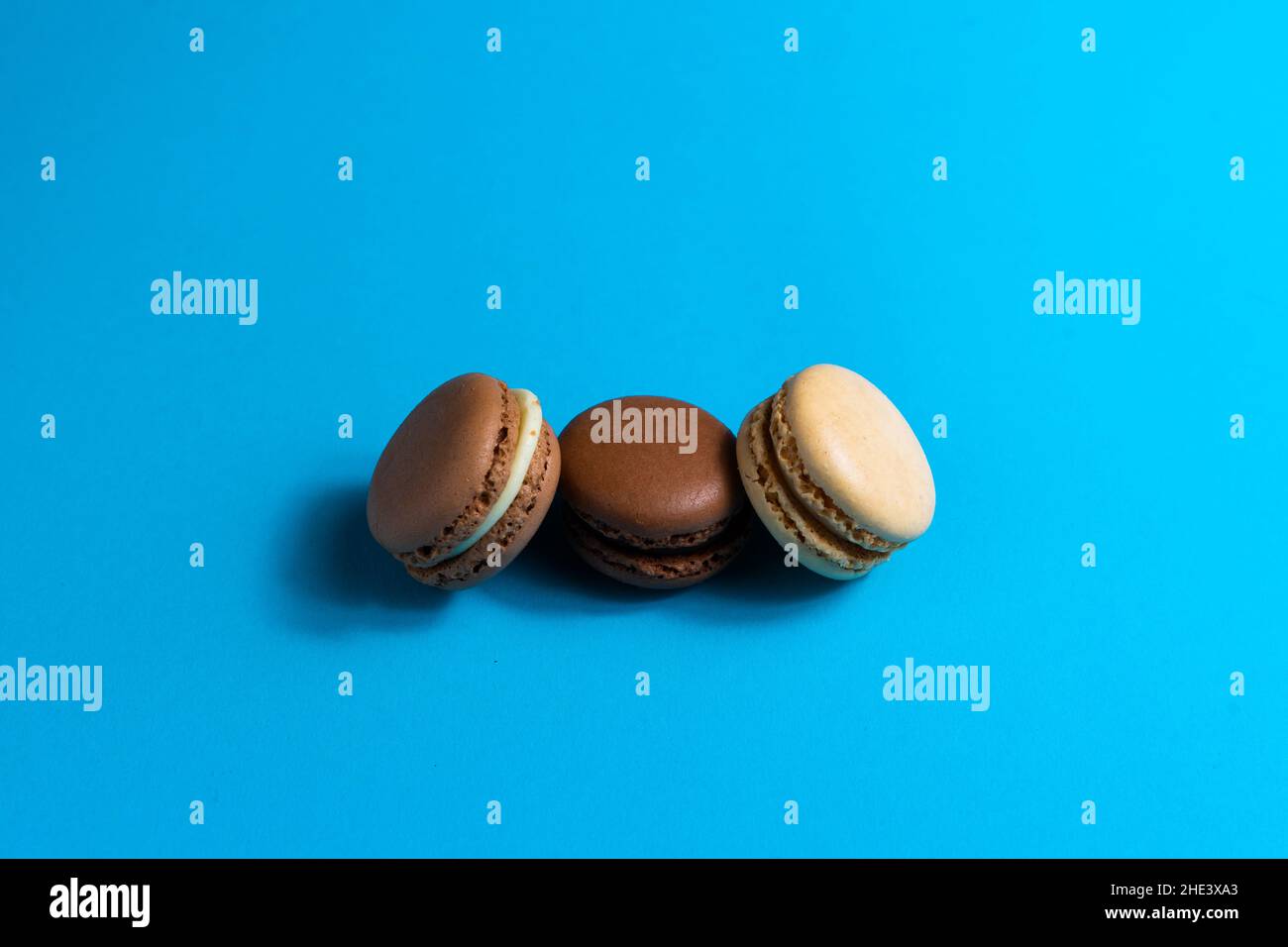 Macaron o macarone colorato su sfondo blu. Disposizione piatta, vista dall'alto, spazio di copia Foto Stock