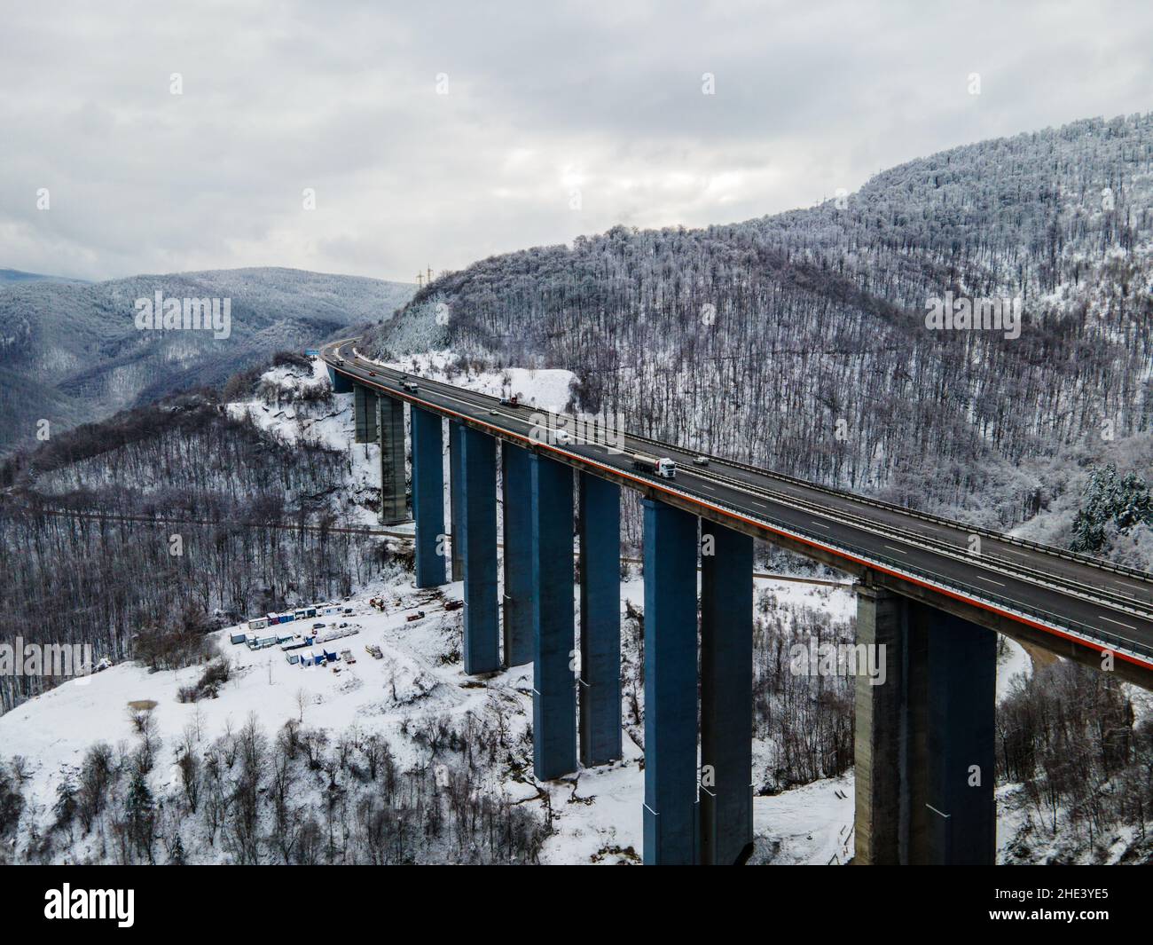 Splendida vista aerea di una strada. Splendido paesaggio innevato con fiume e alberi. Auto che guidano su strada. Colpo di drone di neve. Foto di alta qualità Foto Stock