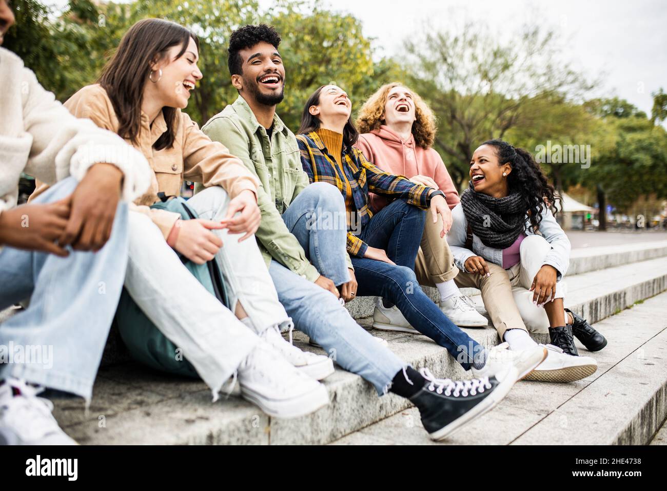 Gruppo multirazziale di giovani amici studenti adolescenti che ridono insieme all'aperto Foto Stock