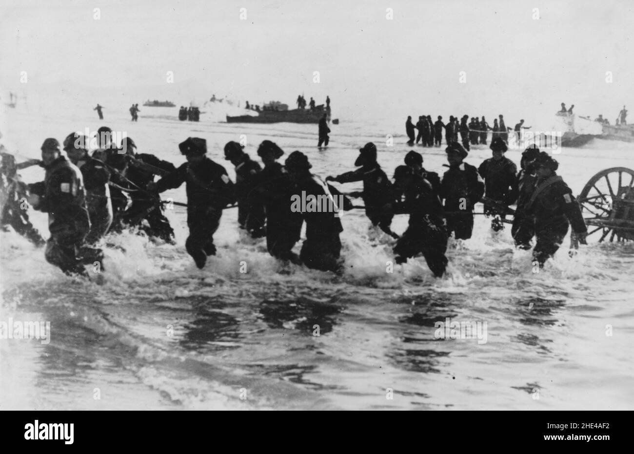 Seconda Guerra sino-giapponese, 1937-1945. Le truppe giapponesi della forza navale speciale di atterraggio scaricano dalle chiatte di atterraggio e si sfilano a terra con i loro pezzi di artiglieria in stoppa mentre si muovono per afferrare la città costiera di Tsingtao (Qingdao), 14th gennaio 1938. Foto Stock