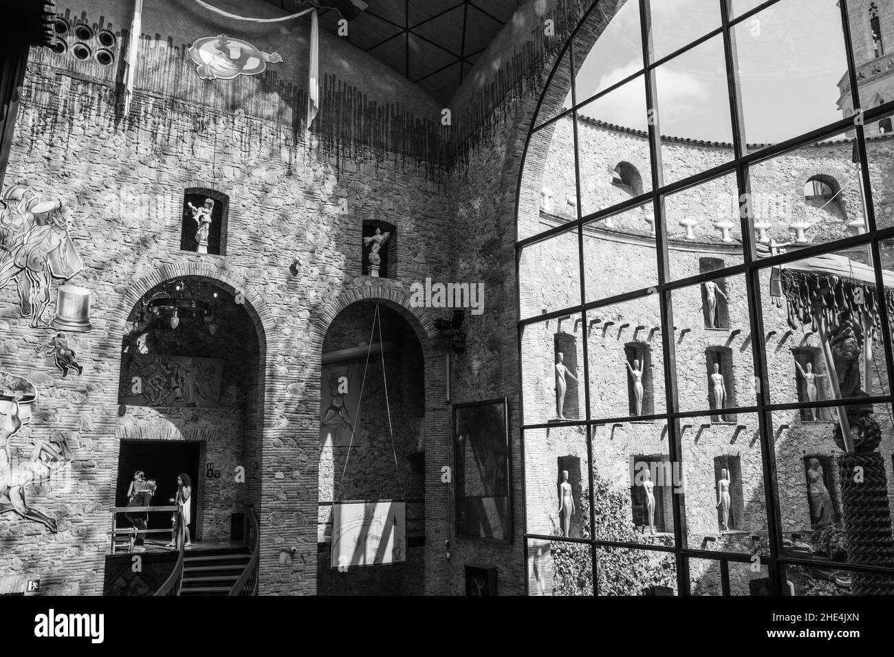 Scala di grigi di finestre panoramiche nel museo Dali con figure all'interno delle pareti a Figueras, Spagna Foto Stock