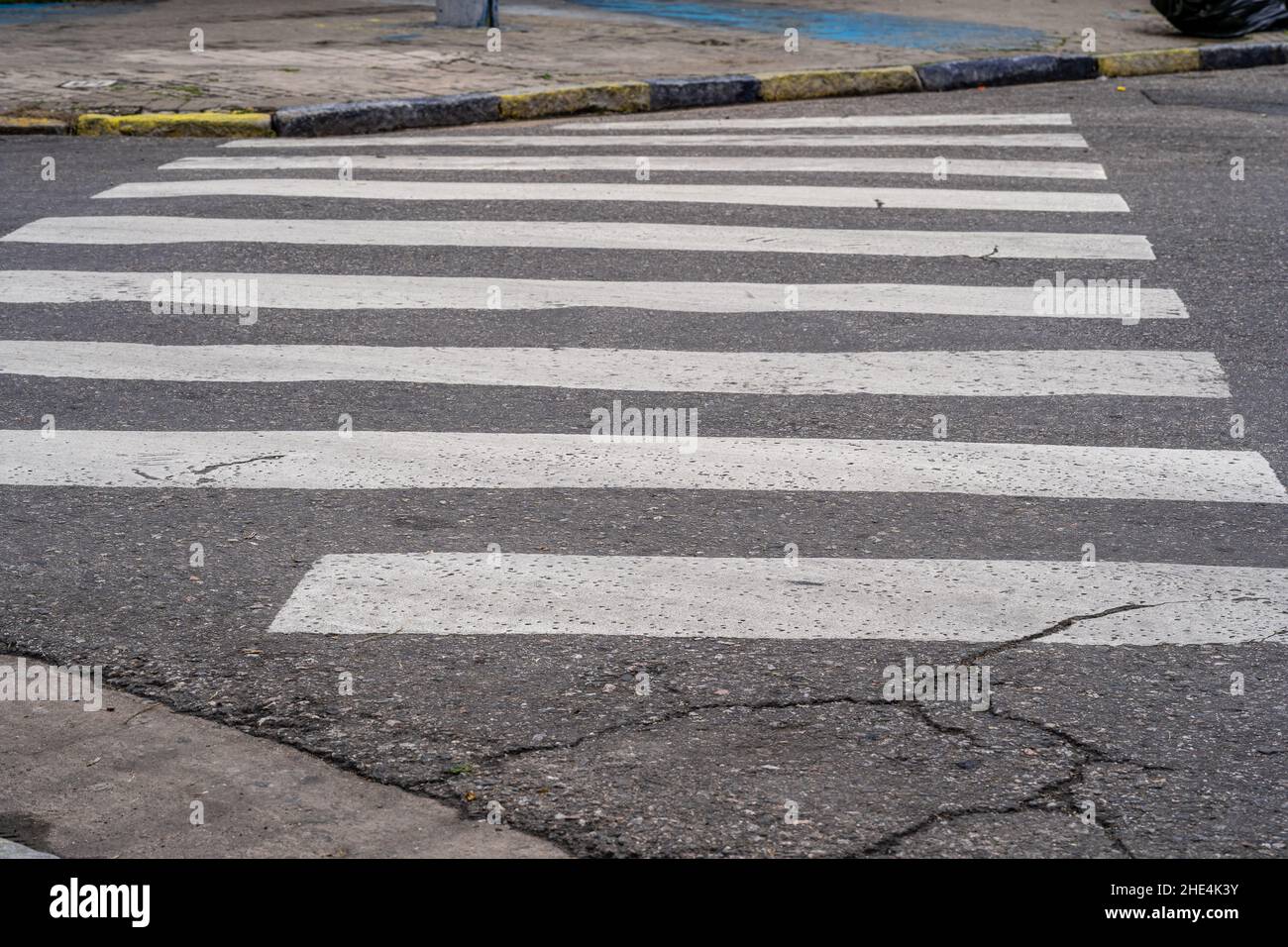 Zebra attraversa i pedoni su una strada danneggiata per una guida sicura Foto Stock