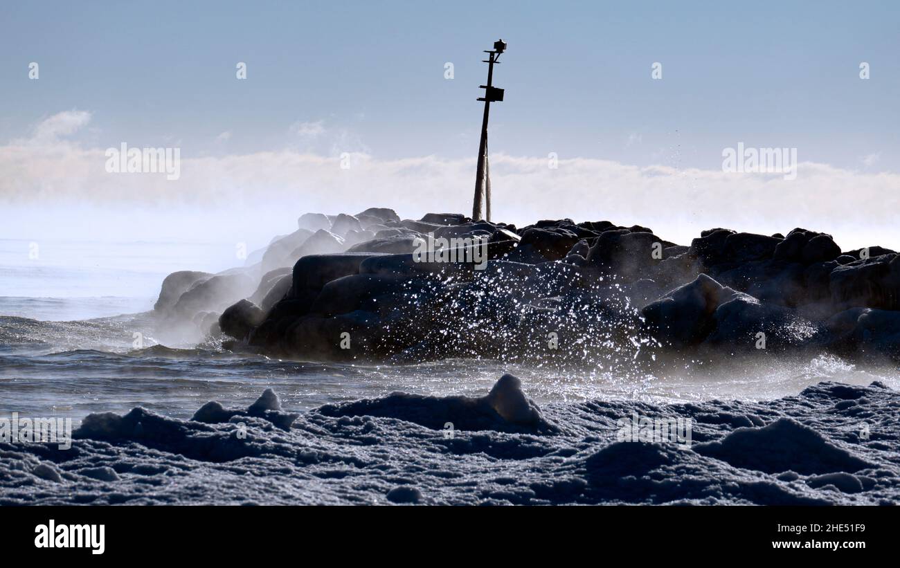 Le onde si infrangono contro la ghiacciata costa del lago Michigan con il vapore che fuoriesce dall'acqua a temperature inferiori allo zero. Preso a Gillson Beach a Wilmette, il Foto Stock