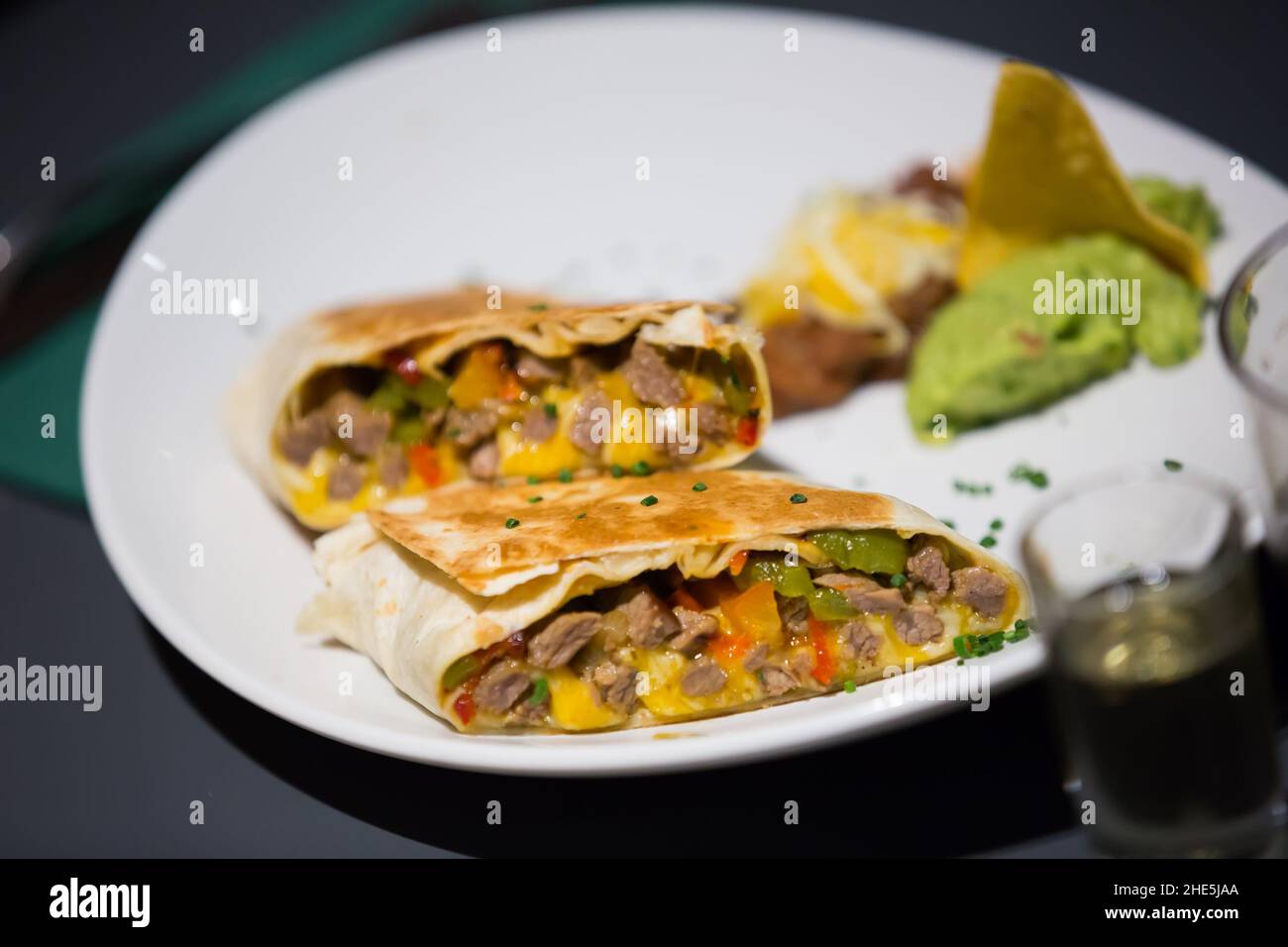 Burrito Tex-mex con carne in sause su piatto Foto Stock