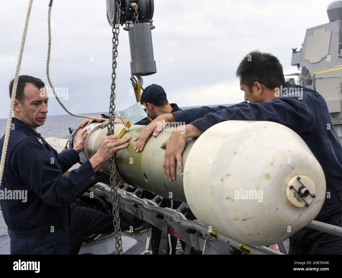 I marinai abbassano un siluro da esercizio recuperabile sul vassoio di caricamento del tubo di Torpedo del serbatoio di superficie MK 32 (32109404761). Foto Stock