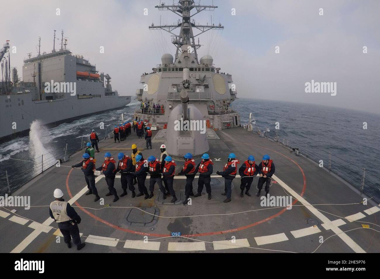 Marinai di USS Carney (DDG-64) che tengono linea telefonica e di distanza durante il rifornimento in corso con USNS Robert E. Perry (T-AKE-5) US Navy 170328 Foto Stock