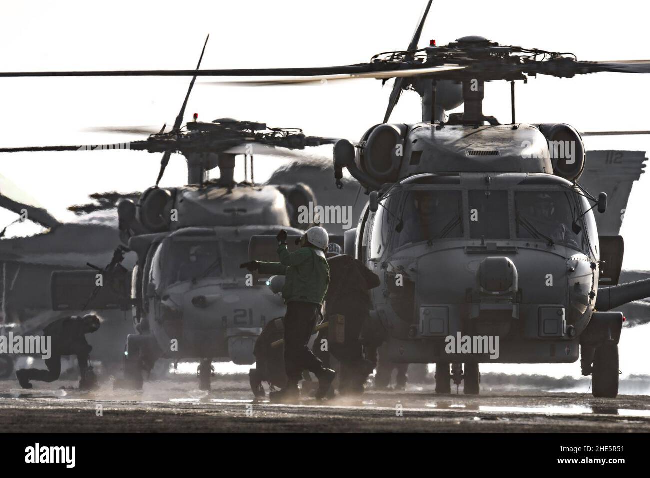 I marinai rimuovono i cunei e le catene da un elicottero MH-60R Seahawk. (28278532493). Foto Stock