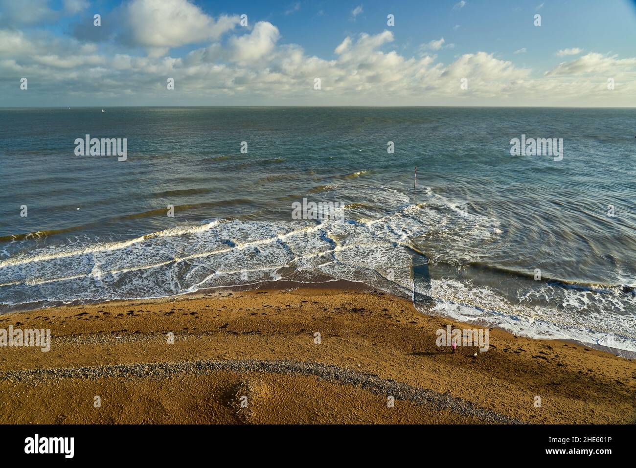 Bella scena di onde ventose nel mare blu con un cielo blu nuvoloso all'orizzonte vicino alla spiaggia Foto Stock