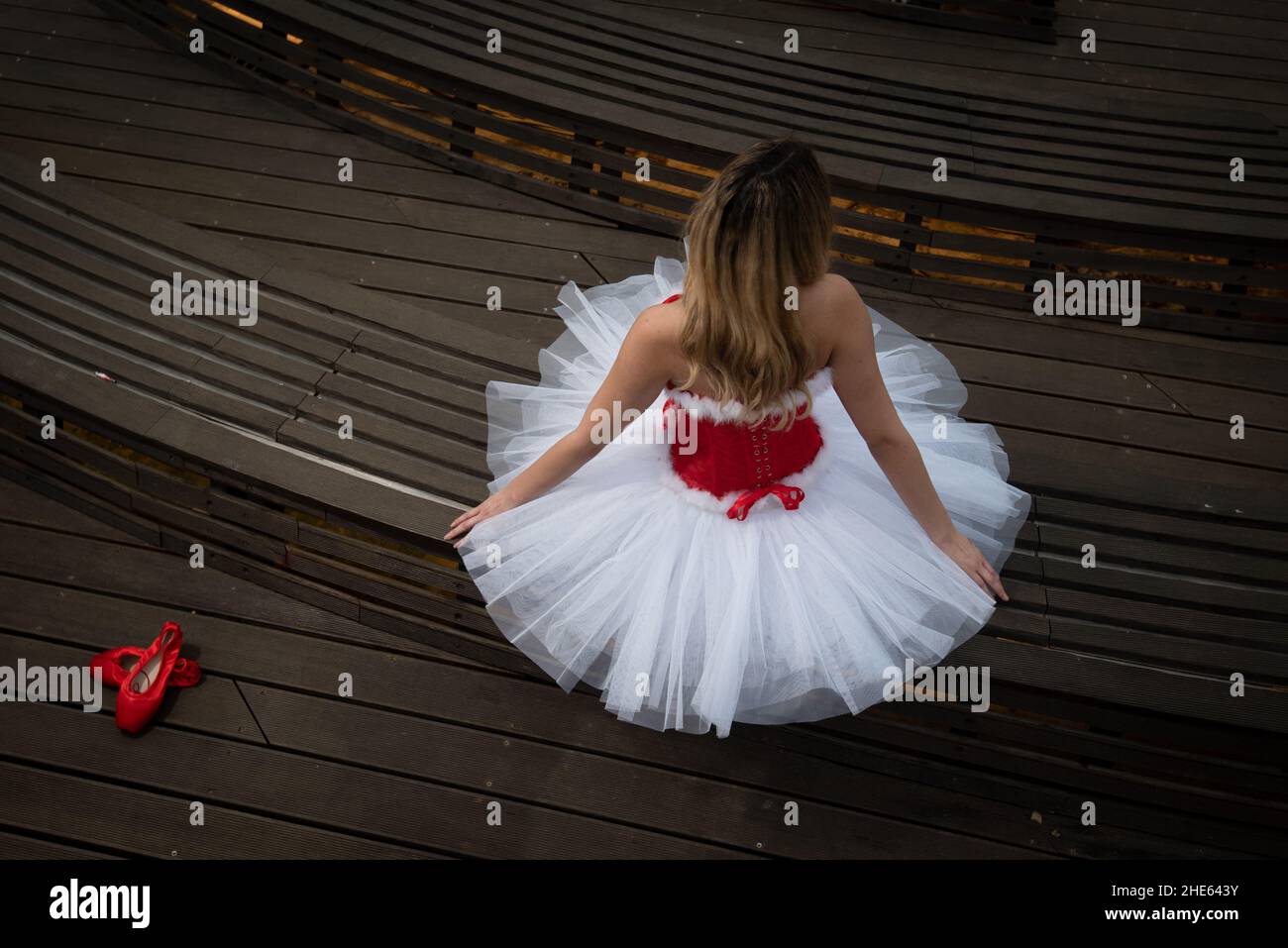 Ballerina con abito rosso bianco di natale in posa sul pavimento Foto Stock