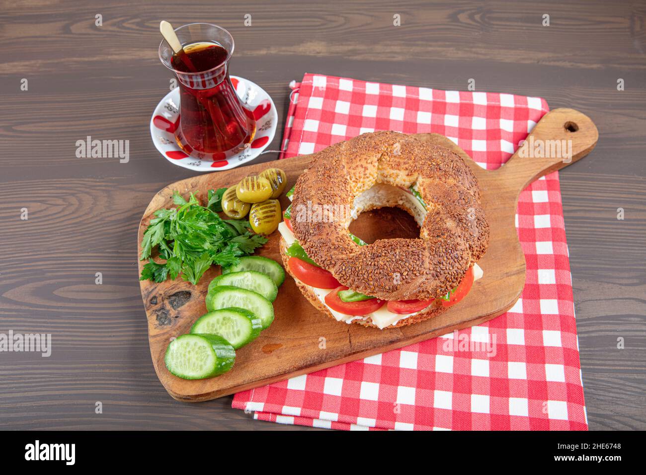 Panino turco Bagel Simit. Bagel vegano fatto a casa con formaggio, pomodoro e cetriolo su sfondo ligneo. Colazione turca veloce Foto Stock