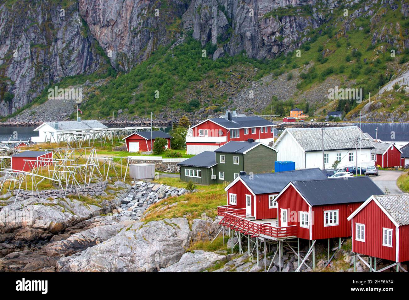 Tipiche cabine di pesca Rourbuer nel villaggio di Lofoten Nusfjord in una giornata piovosa, in estate. Tradizionali case in legno rosso norvegese Foto Stock