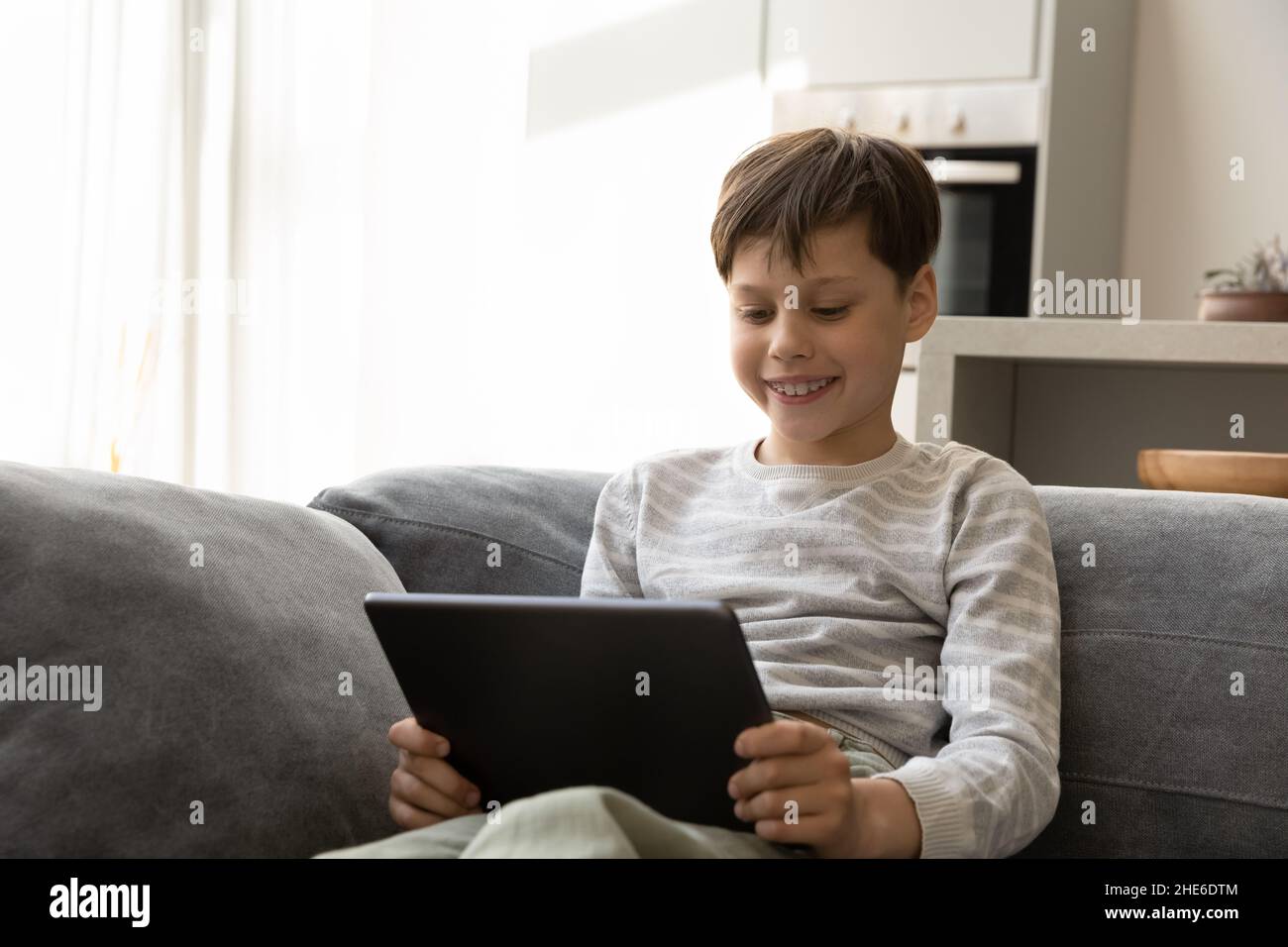 Allegro sorridente gen Z adolescente bambino guardando lezione virtuale Foto Stock