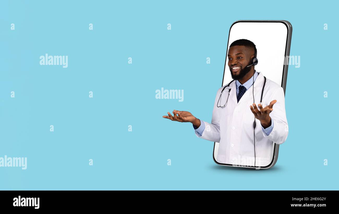Concetto di telemedicina. Black Doctor in Headset che esce dal grande schermo dello smartphone Foto Stock