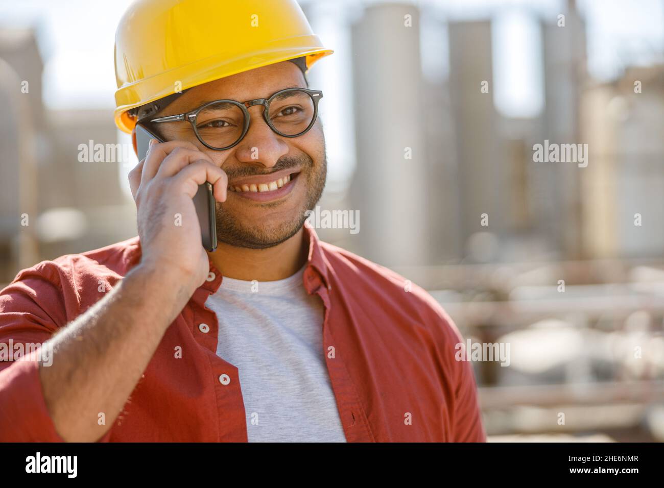 Sorridente giovane ingegnere industriale che lavora in stabilimento Foto Stock