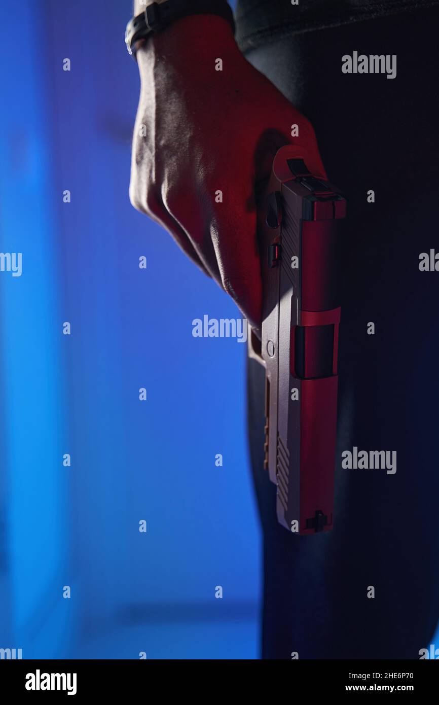 Pistola in mano abbassata di maschio in studio Foto Stock