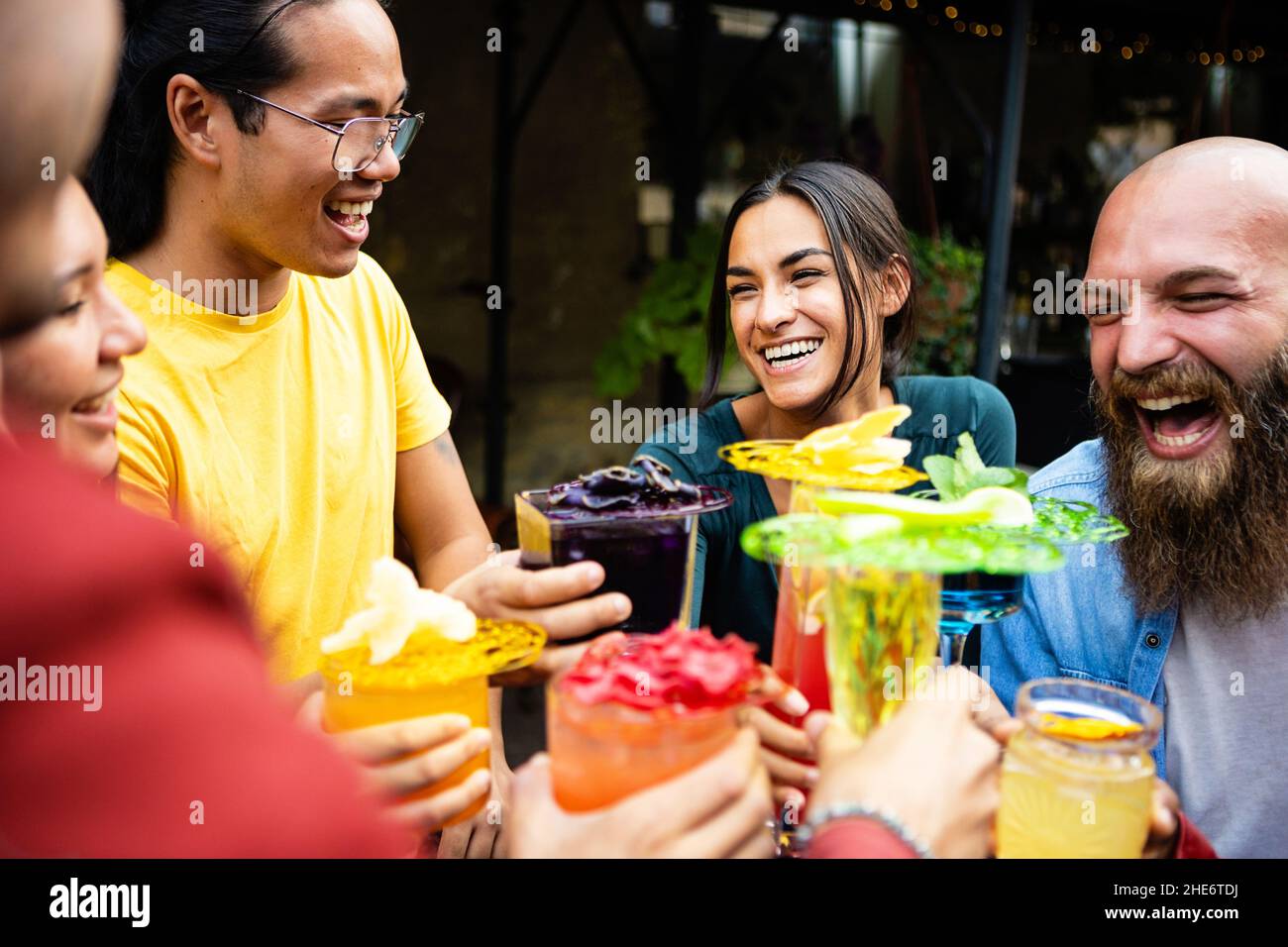 Buon gruppo multietnico di amici che bevono cocktail alla moda in un bar sulla terrazza Foto Stock