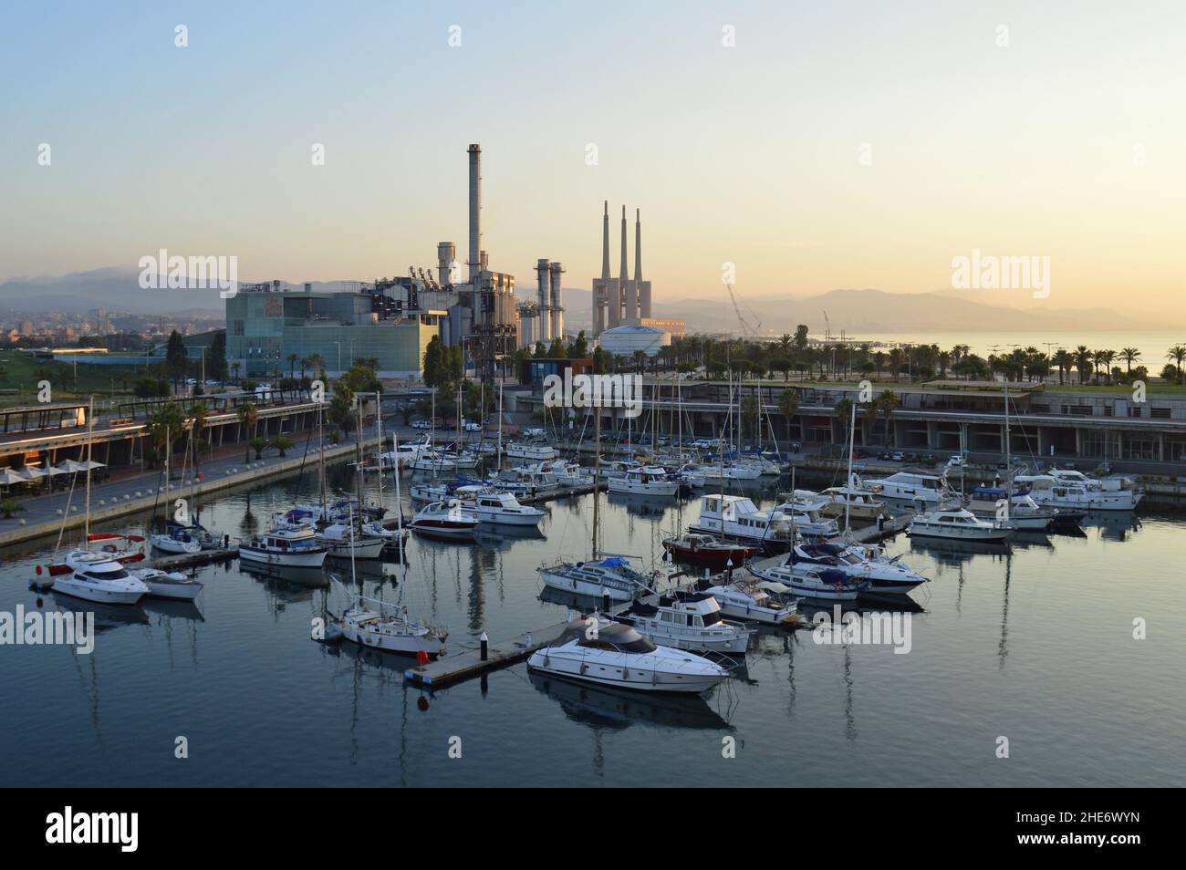 Yacht a Port Forum all'alba con la centrale termica Sant Adria de Besos in background, Barcellona Spagna. Foto Stock