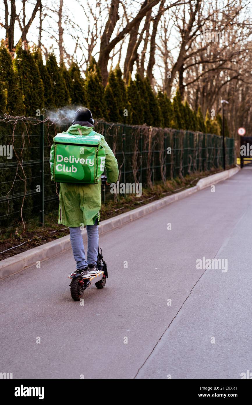 Krasnodar, Russia - Gennaio 7 2022: Giro di ragazzi con consegna di cibo su scooter elettrico con borsa isotermica Foto Stock