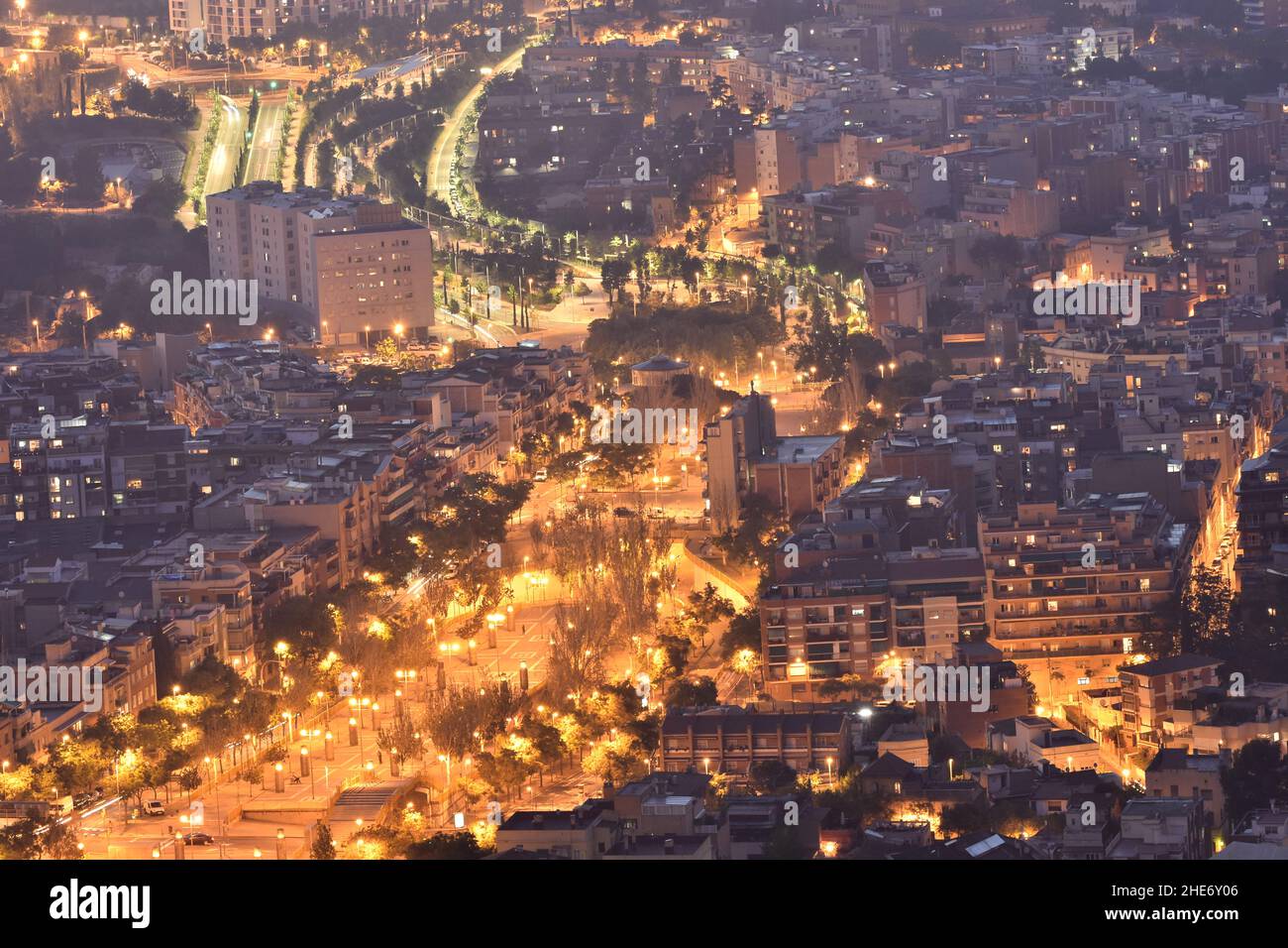 Rambla del Carmel, strada principale nel quartiere Carmel illuminato al crepuscolo, vista dalla collina di Turo de la Rovira a Barcellona Spagna. Foto Stock