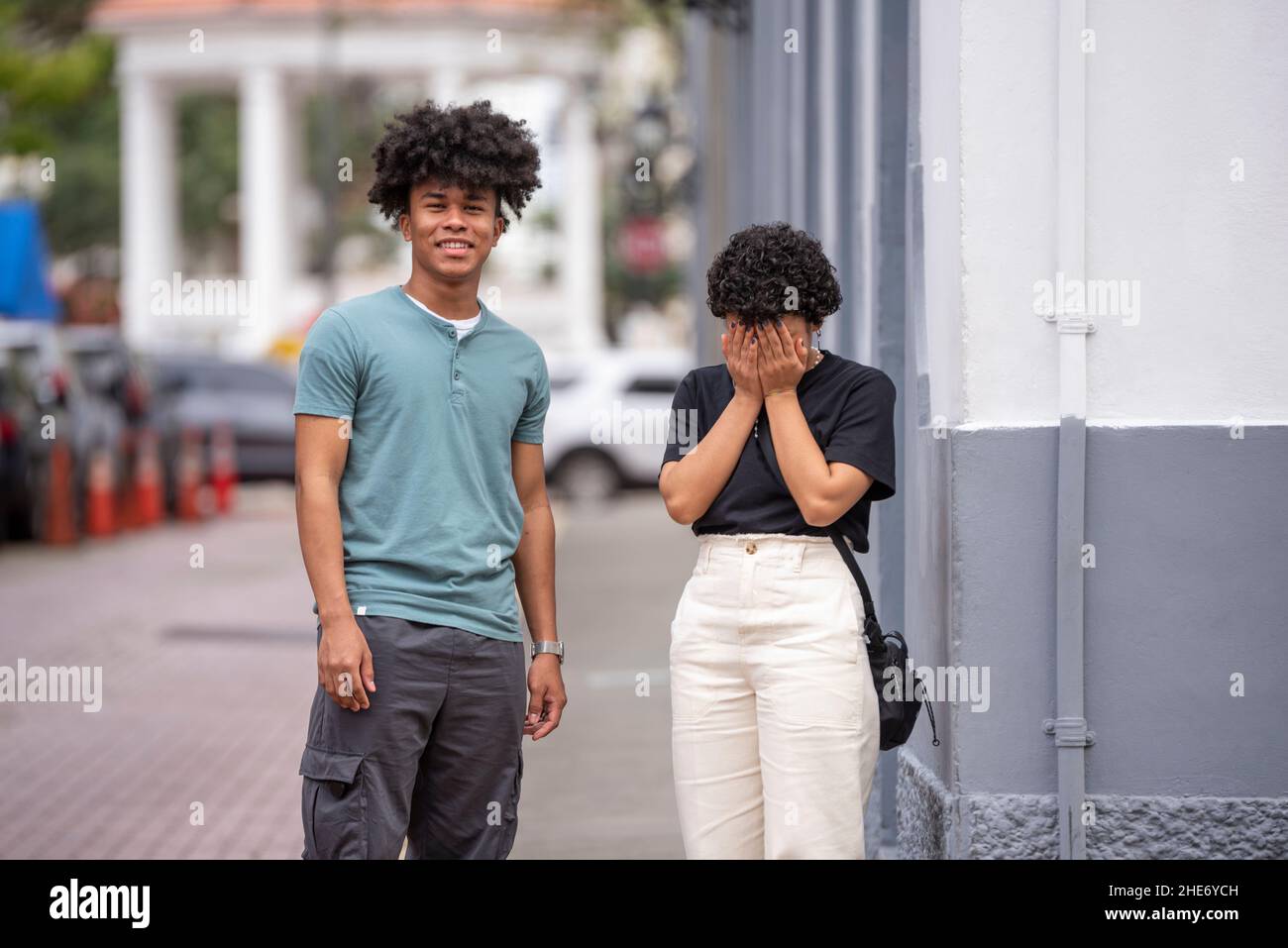 Coppia latina che sventolano le mani sul marciapiede, Città di Panama Foto Stock