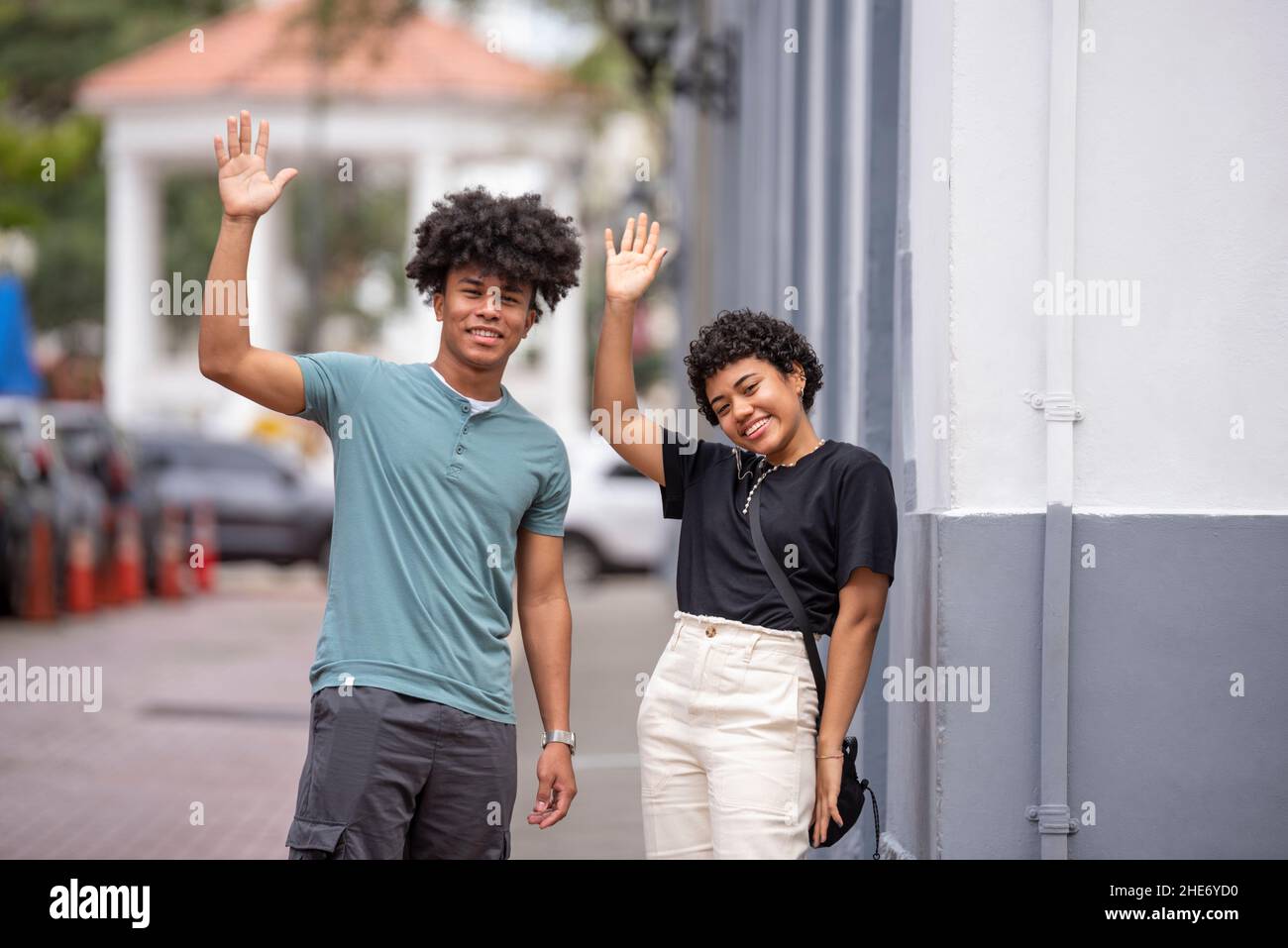 Coppia latina che sventolano le mani sul marciapiede, Città di Panama Foto Stock