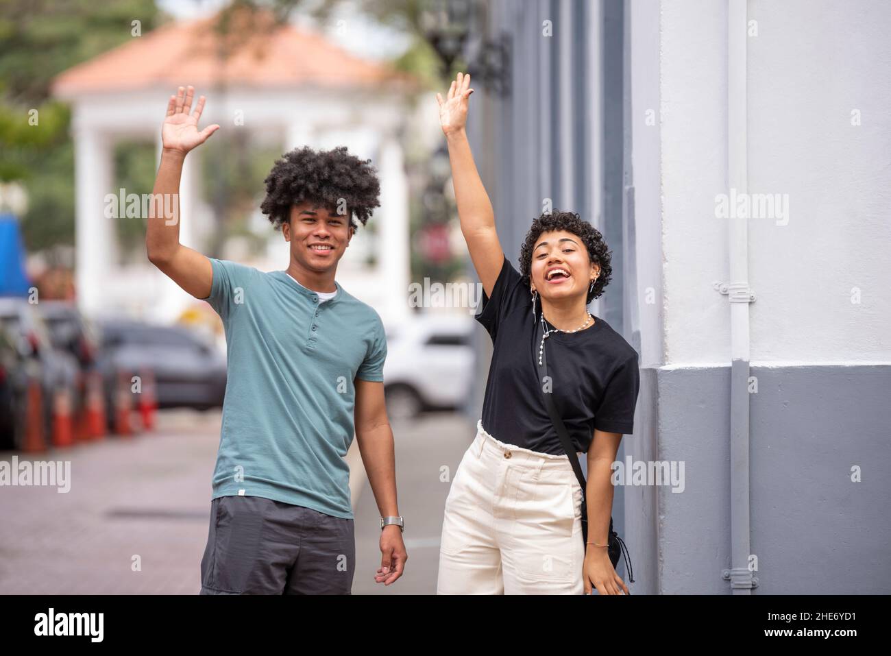 Coppia latina che sventolano le mani sul marciapiede, Città di Panama Foto Stock