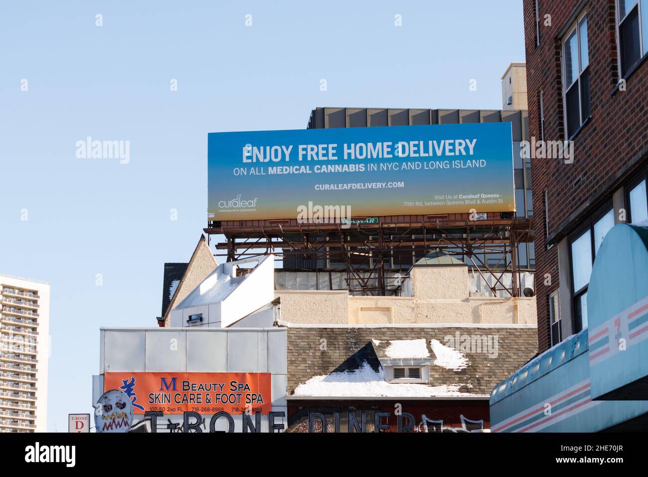 Un cartellone pubblicitario di consegna a domicilio gratuita per cannabis medica o marijuana a New York City e Long Island da Curaleaf contro un cielo blu chiaro Foto Stock