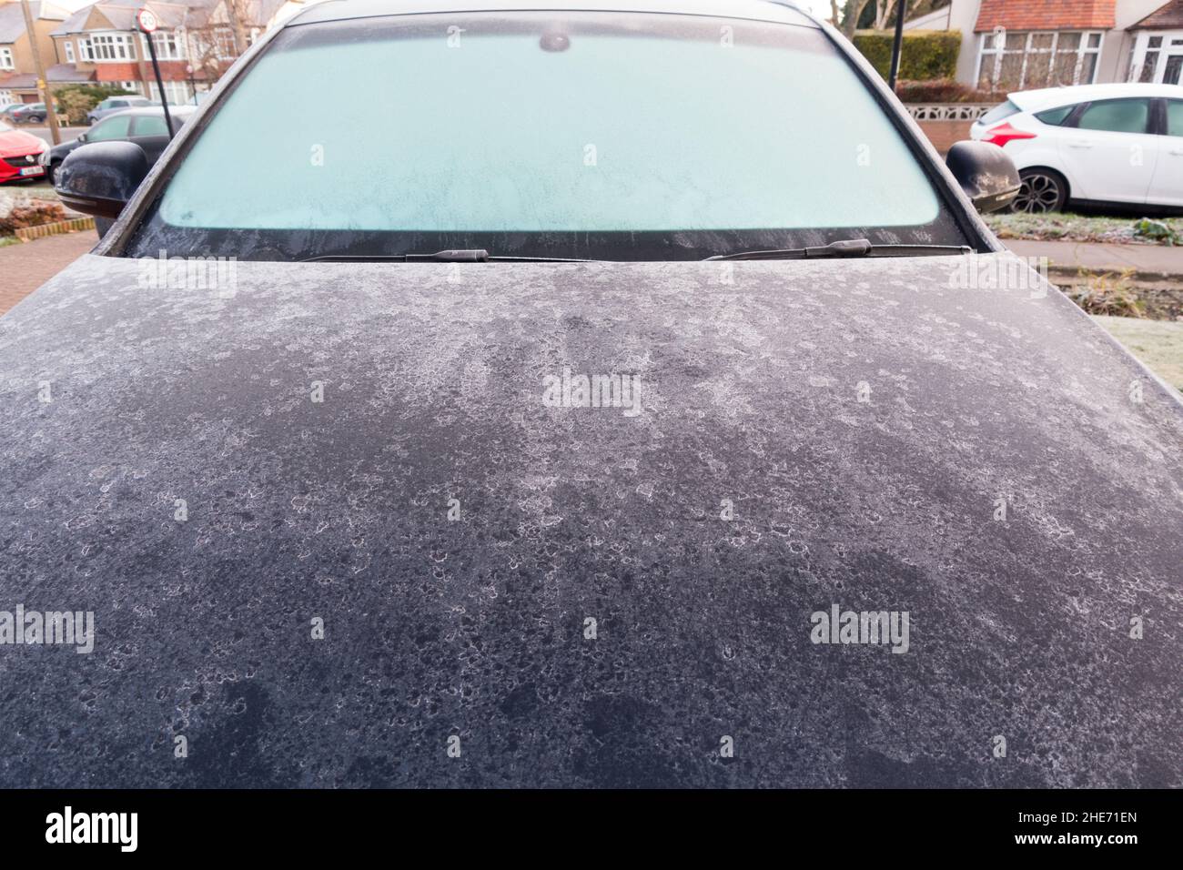 Vista frontale del cofano e del parabrezza di un'auto ricoperti di ghiaccio Foto Stock