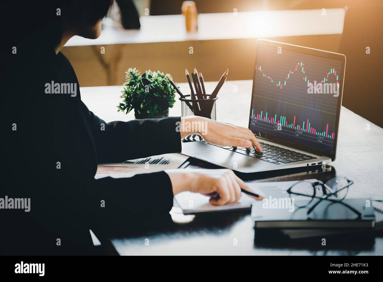 Concetto di pianificazione finanziaria e di investimento, donna d'affari femminile che utilizza il computer per analizzare i grafici per trovare punti di ingresso su un bordo di negoziazione. Attraverso Foto Stock