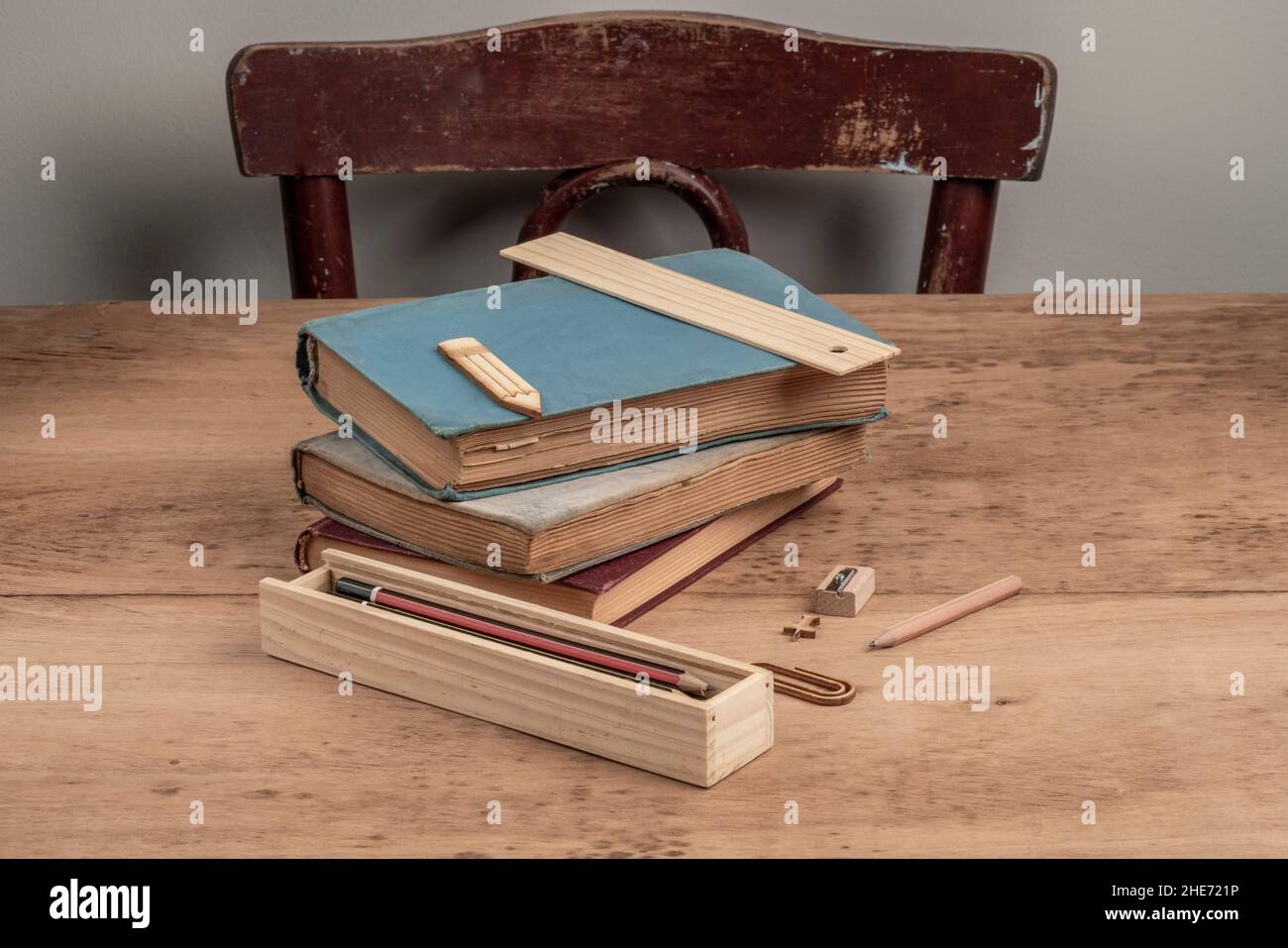 modello di ritorno a scuola con pile di libri e matite su un tavolo di legno con spazio di copia Foto Stock