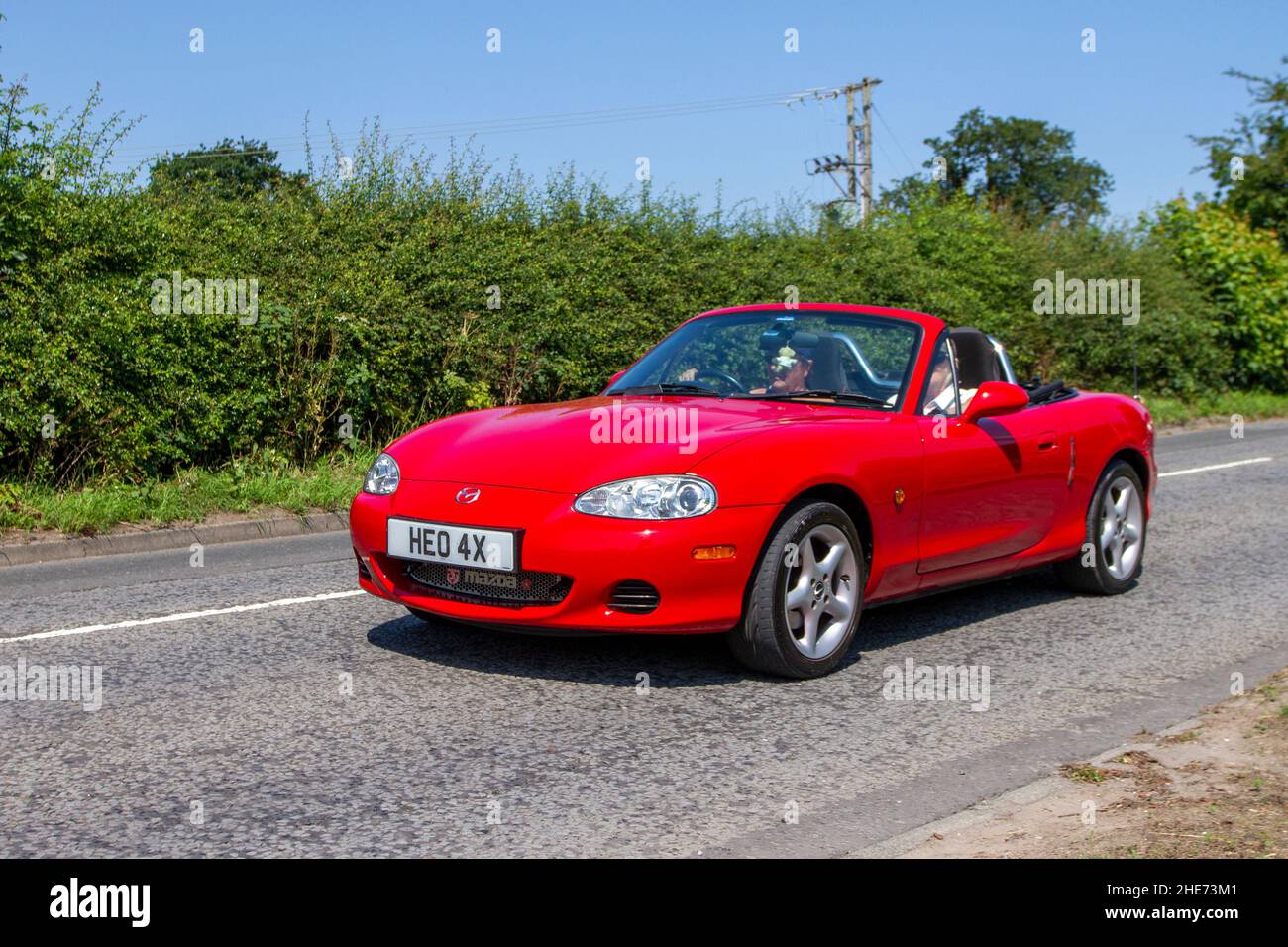 2002 Mazda MX-5 i rosso, 1598cc 5 velocità manuale lungo il tragitto per Capesthorne Hall classica mostra di luglio, Cheshire, Regno Unito Foto Stock