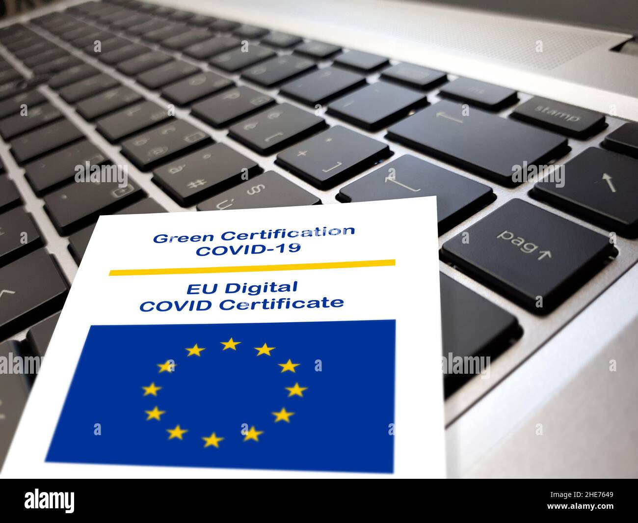 Primo piano del certificato verde Covid-19 del documento dell'Unione europea sulla tastiera di un notebook. Foto Stock