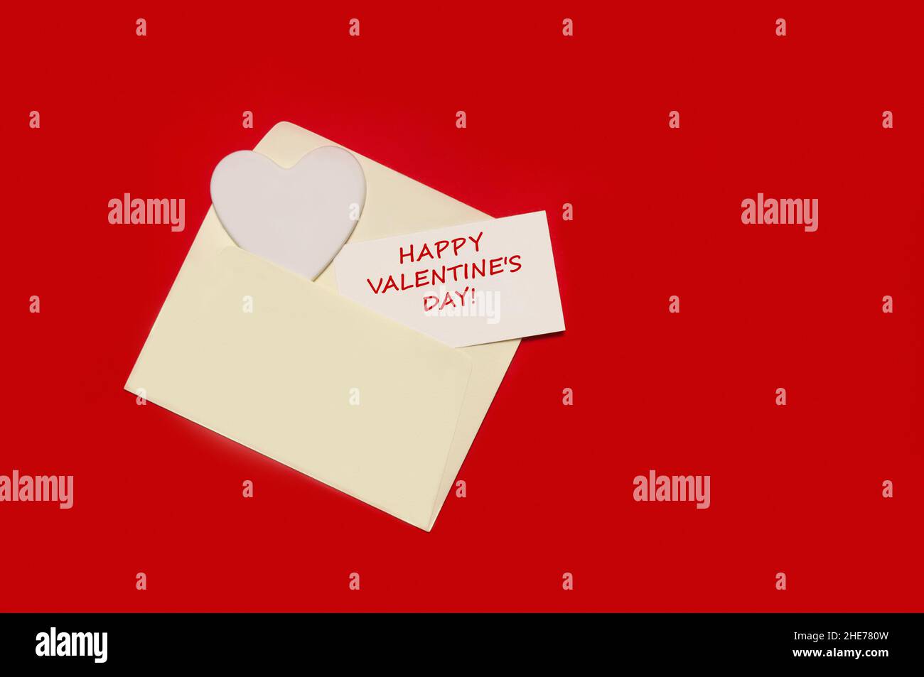Busta con cuore e San Valentino congratulazioni su sfondo di carta rossa. Biglietto d'auguri mockup Foto Stock