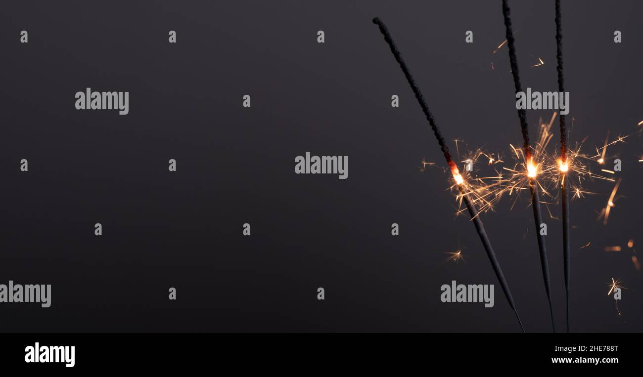 Primo piano del fuoco bruciante bastone su sfondo grigio Foto Stock