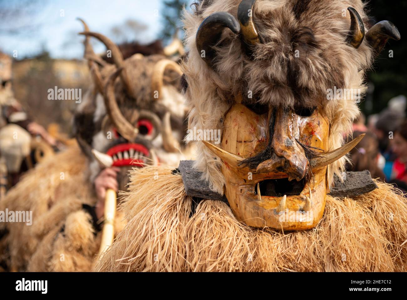 Ballerini Kukeri con costumi intricati, grandi campane e maschere che ballano durante il tradizionale festival annuale di Sofia, Bulgaria. Kukeri è una tradizione secolare destinata a cacciare gli spiriti malvagi e a invitare il bene, tenuto intorno all'inverno o metà inverno. Foto Stock