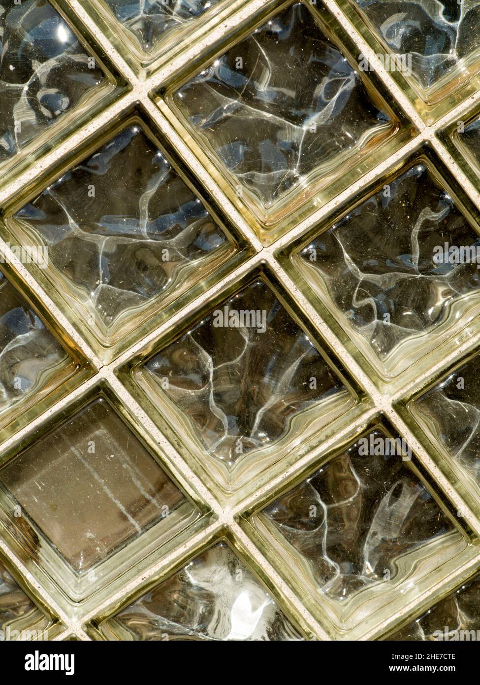 Scoprire la bellezza nascosta nelle forme strutturate dove la luce si rifrange in motivi fluidi, trasformando la semplice muratura in vetro in un'opera d'arte. Foto Stock