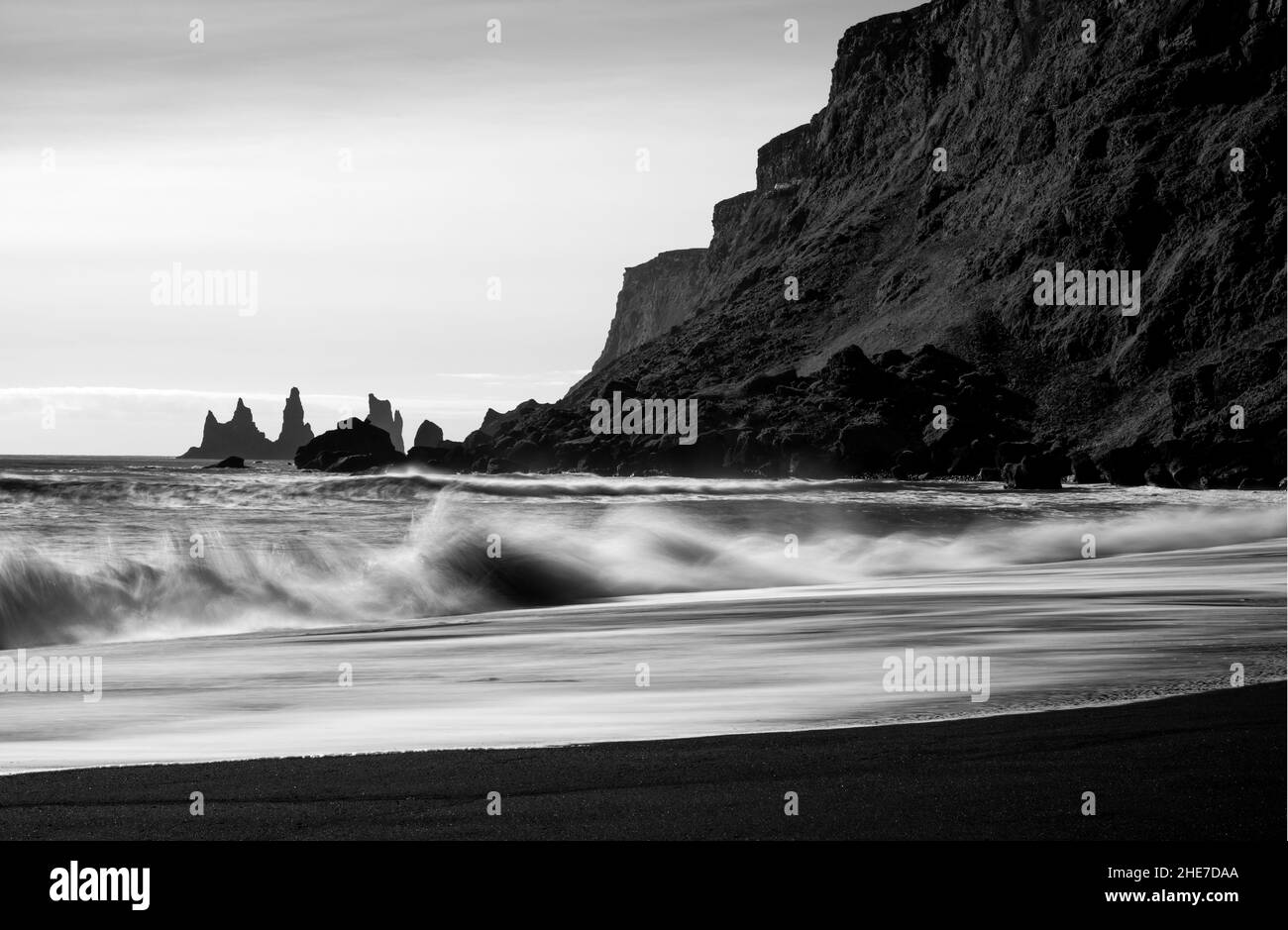 Bella vista delle onde di mare che toccano la spiaggia vicino alla collina rocciosa Foto Stock