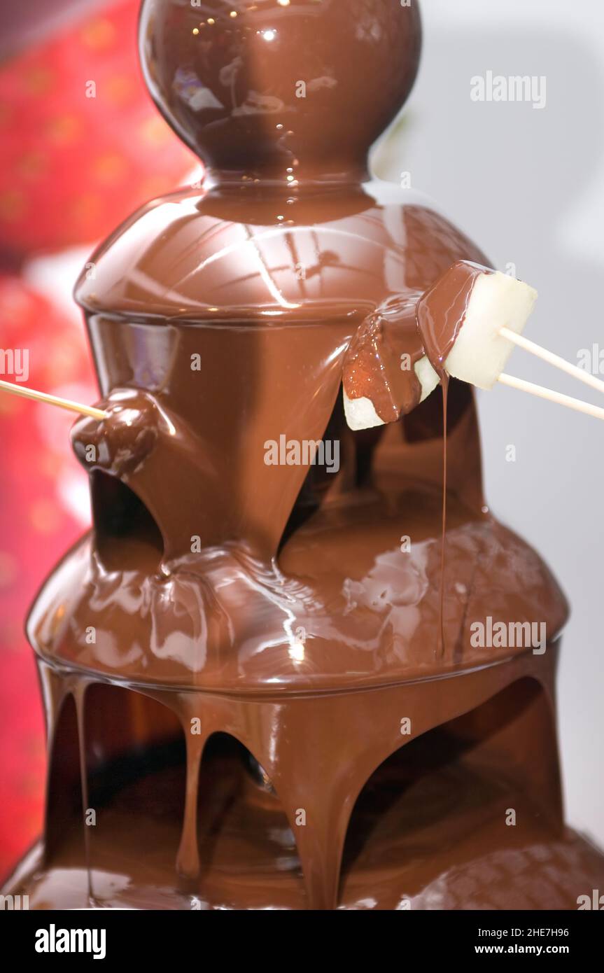 fontana di cioccolato fuso a una festa per mangiare con frutta Foto Stock