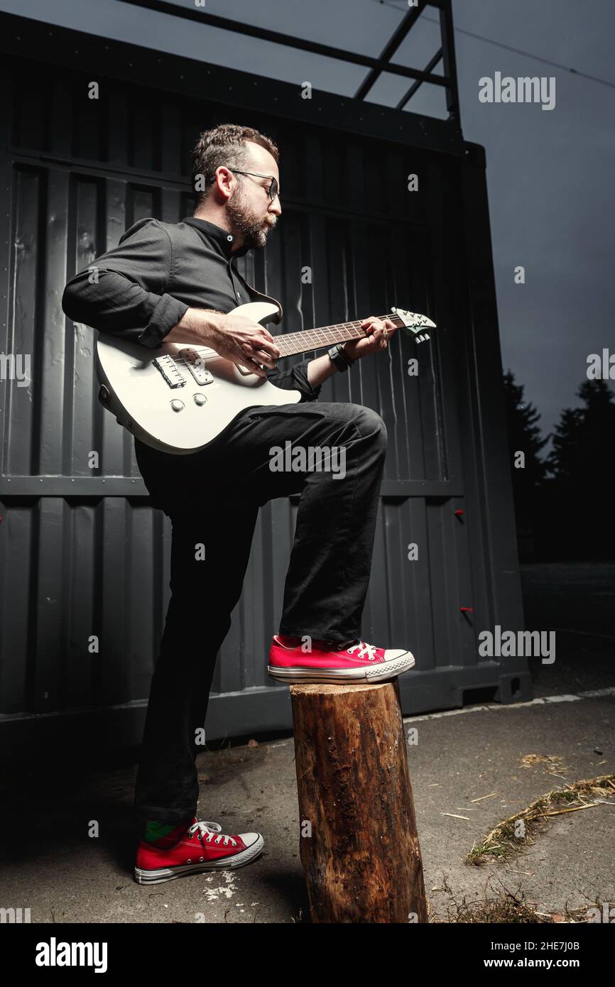 Ritratto di un chitarrista maschile con chitarra elettrica che indossa abiti neri. Concetto di carattere rock musicista Foto Stock