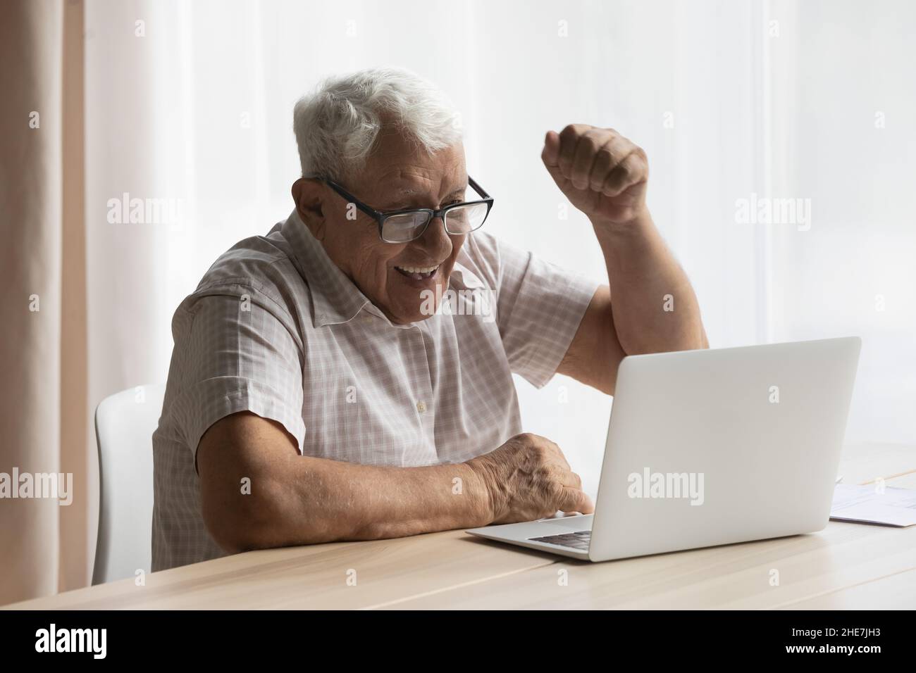 Ridendo gioioso vecchio pensionato uomo celebrare il successo. Foto Stock