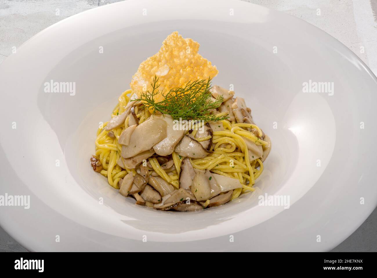 Tagliolini passato italiano con funghi porcini. Tajarin piemontese con Boleto di funghi con finocchio e parmigiano in piatto bianco Foto Stock