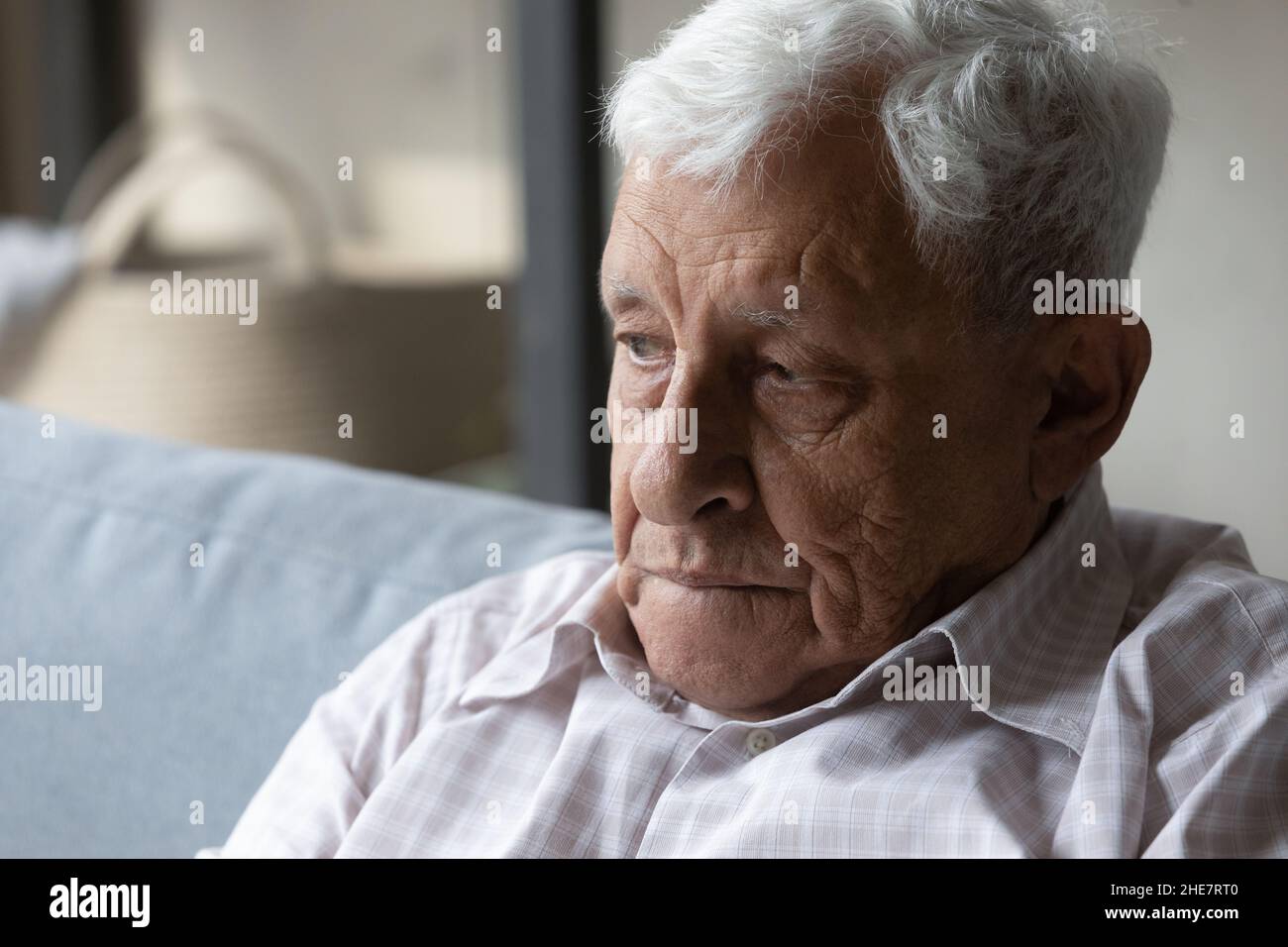 Perso in pensieri negativi infelice vecchio seduto sul divano. Foto Stock