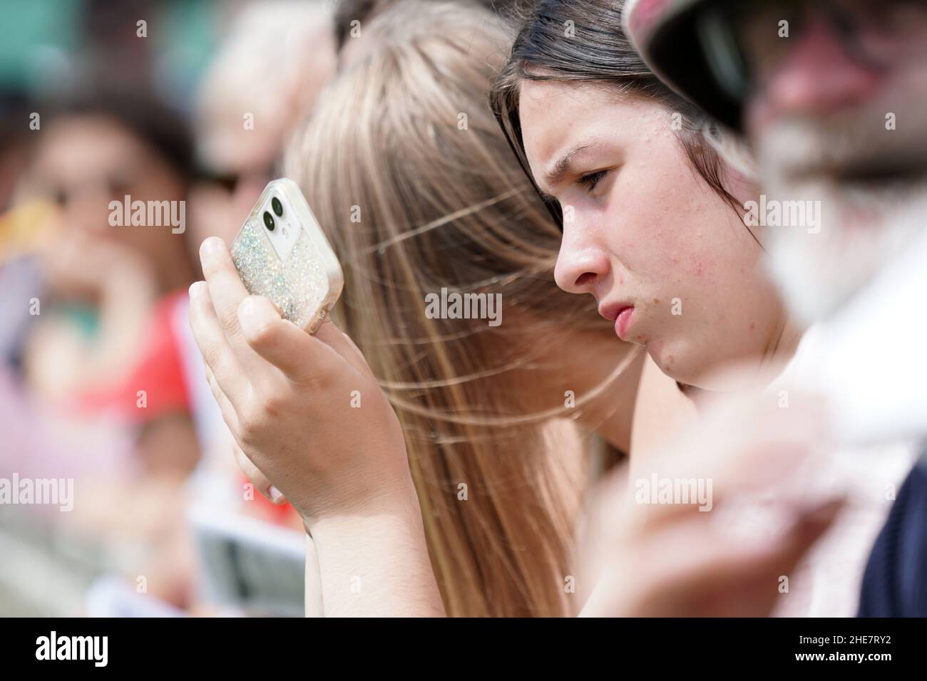 KUMARA, NUOVA ZELANDA, 8 GENNAIO 2022; una giovane donna non identificata controlla il suo telefono in attesa di una gara per iniziare al Kumara Race Track, 8 gennaio 2022 . Foto Stock
