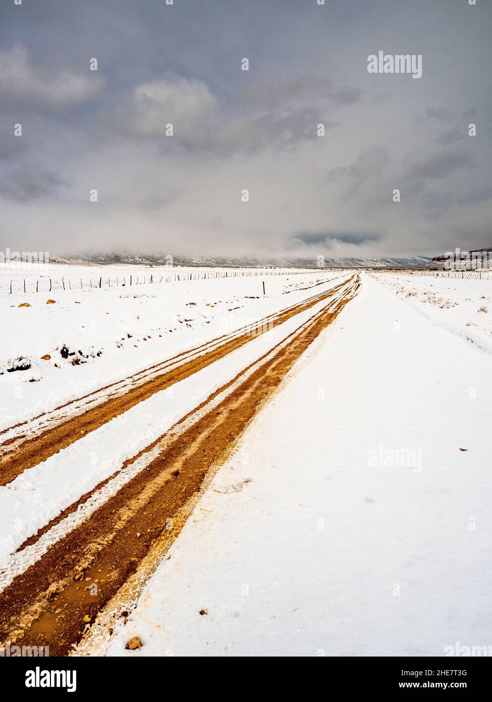 House Rock Road a nord dell'autostrada 89A in Arizona con copertura di neve e solchi. Nuvole tempesta invernale in lontananza. Foto Stock