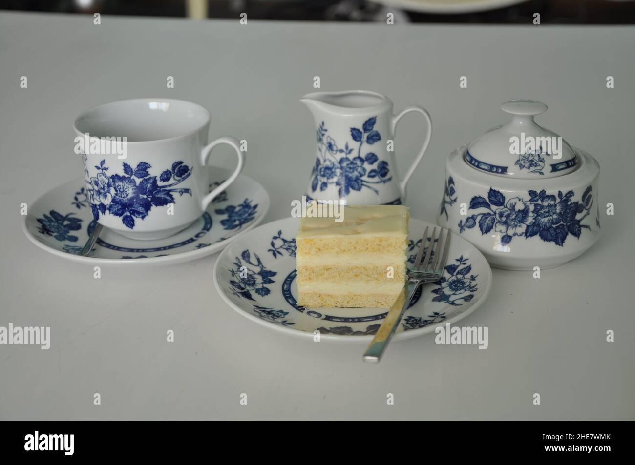 Set in porcellana fine per tè/caffè e cheesecake su piastra. Tè in stile vecchia scuola al servizio di cinque pomeriggio dolce tavolo tradizionale, formaggio sug Foto Stock