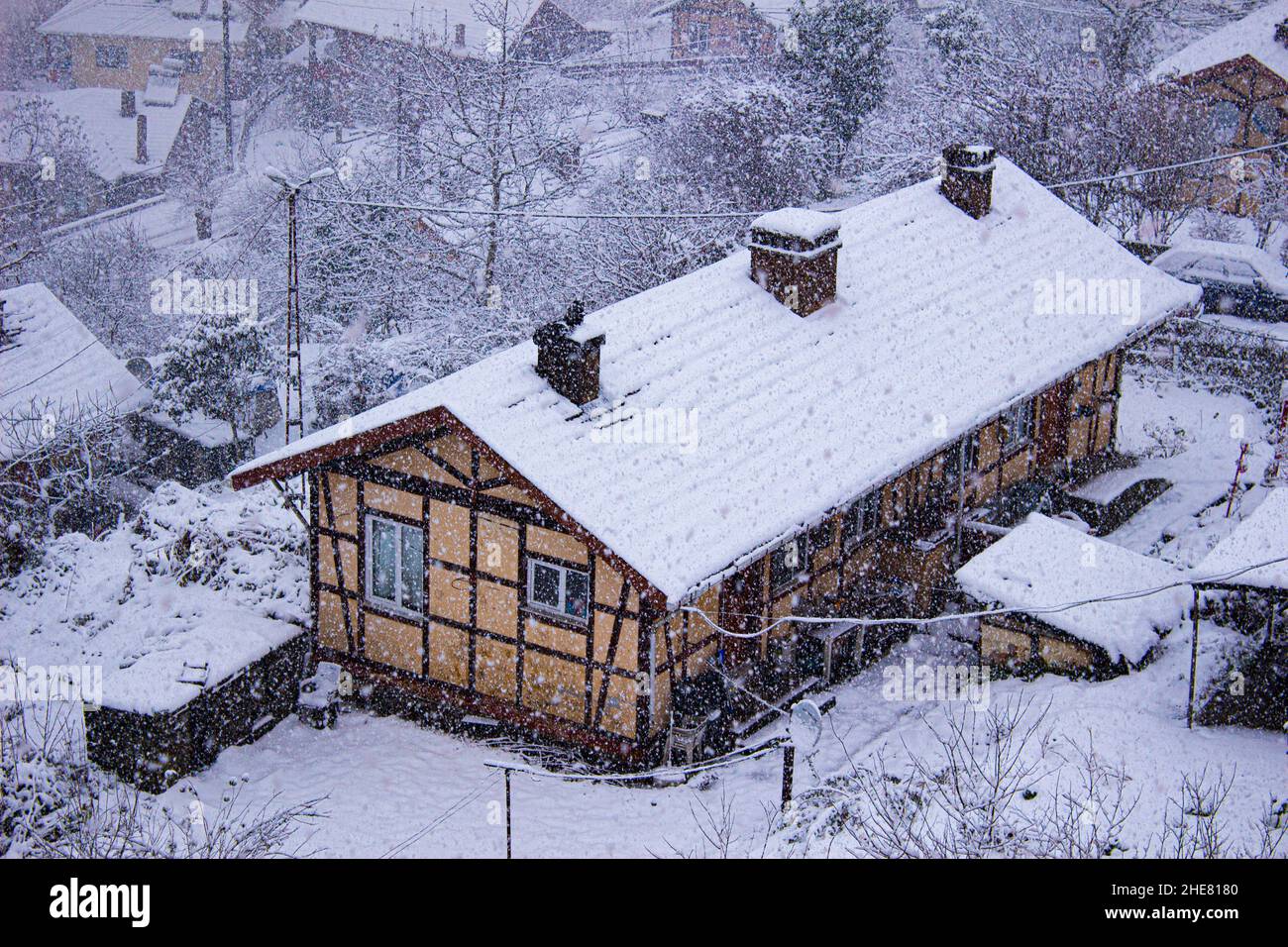 Case d'inverno e vecchie. Immagini della casa mentre sta nevicando Foto Stock
