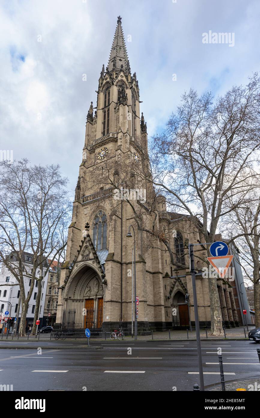 Chiesa cattolica 'Herz Jesu' in piedi nel tempo invernale a Colonia con persone incidentali che camminano di fronte Foto Stock
