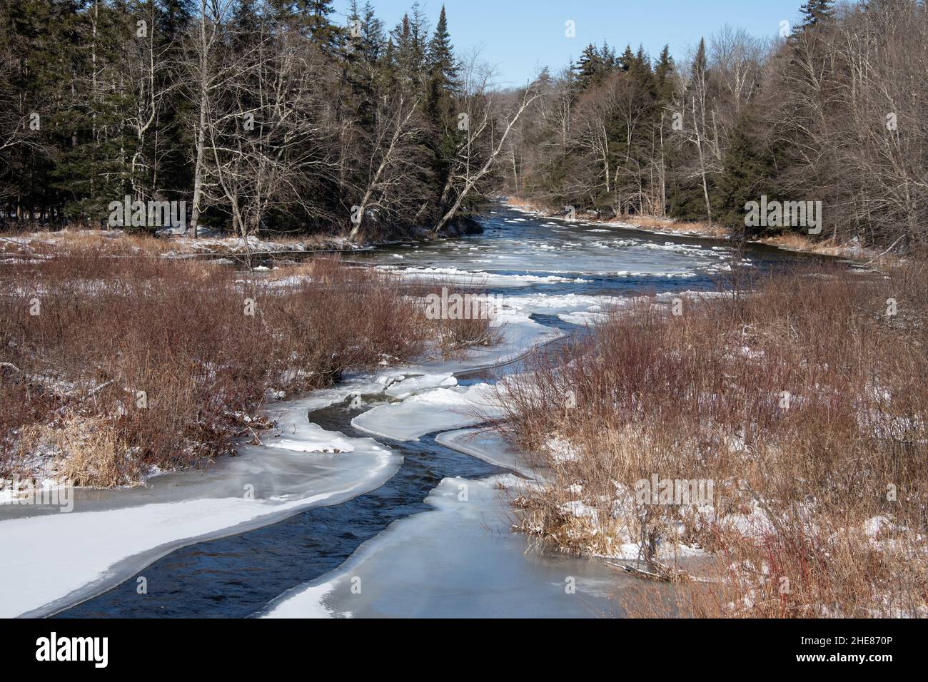 Una vista sul fiume Sacandaga nei monti Adirondack in inverno con neve e ghiaccio sull'acqua. Foto Stock